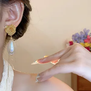 Dettaglio orecchino rosa vintage con perla a goccia d'acqua e nappine a catena fini