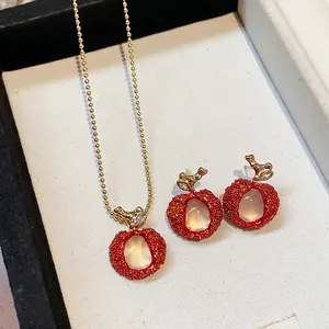 Close-up detail of lychee-inspired red zircon and resin necklace and earring jewelry set