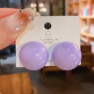 Dettaglio di orecchini a lobo sferici lavanda minimalisti con perni in argento S925.