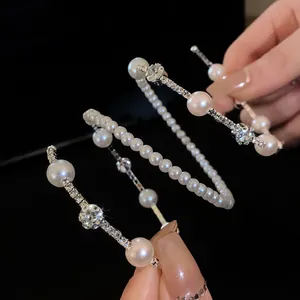 Close-up view of multi-layer spiral bracelet with elegant pearls and sparkling rhinestones