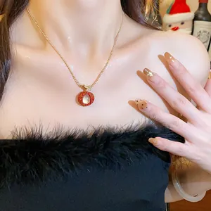 Close-up of elegant gold lychee fruit pendant necklace with red zircon worn by a model