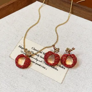 Close-up detail of red lychee zircon and resin jewelry set on a rustic background