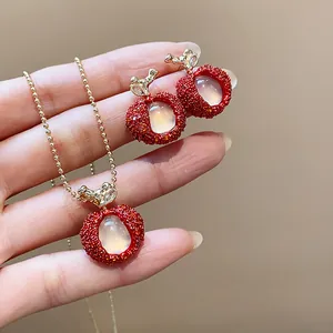 Detailed close-up of a lychee-inspired red jewelry set with resin and zircon stones