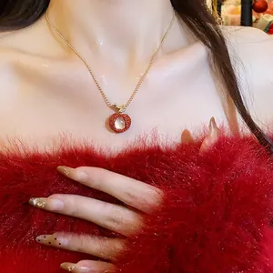 Close-up view of a unique red litchi fruit pendant necklace with zircon and resin details
