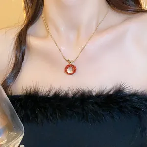 Detailed view of red lychee pendant necklace with zircon and resin on a model.