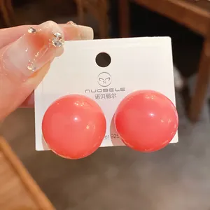 Vista dettagliata di orecchini a perno a sfera rosa oversize con aghi d'argento per lei