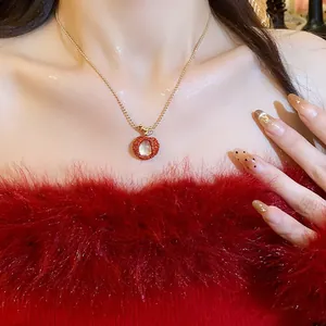 Close-up detail of zircon resin lychee pendant necklace on model wearing red fuzzy top