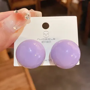Vista dettagliata degli orecchini a bottone a sfera viola con perni in argento S925