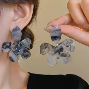 Large flower-shaped resin drop earrings with marble ink-wash pattern and silver pins