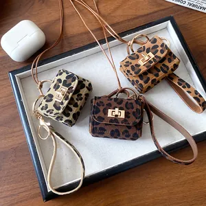 Close-up of three leopard print mini bag necklaces featuring gold turn-lock closures