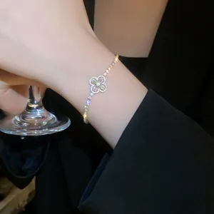 Detail view of a silver-plated four-leaf clover bracelet with sparkling cubic zirconia.