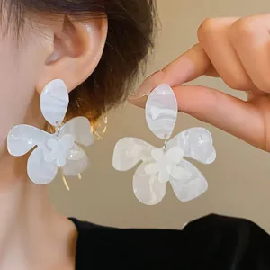 Detailed close-up showing white marble pattern resin flower earrings with silver needles