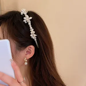 Dettaglio di un cerchietto con fiori e perle su una modella con uno stile romantico.