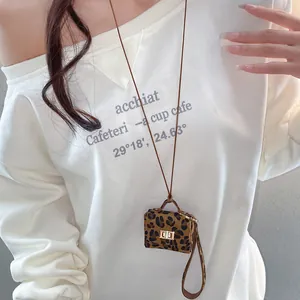 Mini leopard print leather bag pendant necklace for women on white sweatshirt background
