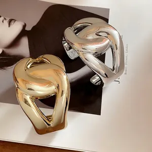 Pair of chunky metallic interwoven cuff bracelets in polished gold and silver finishes
