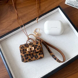Detailed macro view of a leopard print mini bag pendant with a gold clasp and strap.