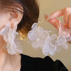 Vista detallada de pendientes de aro con flores de malla rosa y cuentas de cristal brillantes