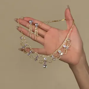 Detailed shot of retro palace style gold crystal necklace and teardrop earrings set