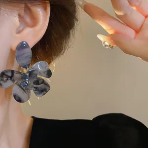 Elegant close-up of forest style resin flower earrings with a marbled purple finish