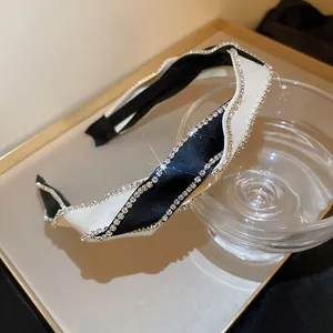 Primo piano di un'elegante fascia per capelli bianca e nera con strass luccicanti