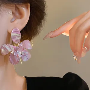 Close-up detail of pink marbled resin flower earring worn for a forest-inspired look.