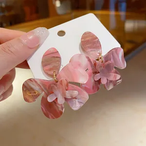 Close-up of pink marbled resin flower earrings featuring an artistic marble texture.