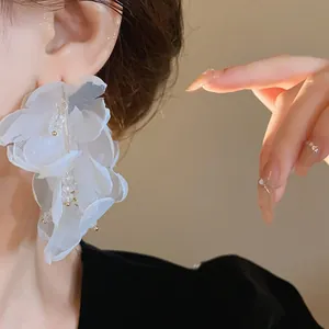 Primer plano detallado de pendientes de flores de malla blanca con detalles de cristal