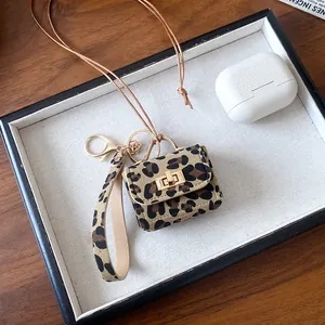 Macro view of leopard print mini bag pendant necklace with fine leather strap and gold-tone clasp