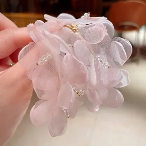 Primer plano detallado de la textura de los pendientes de flores de organza rosa con cristales.