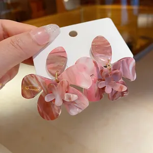 Macro view of pink marbled resin flower earrings featuring intricate petal designs