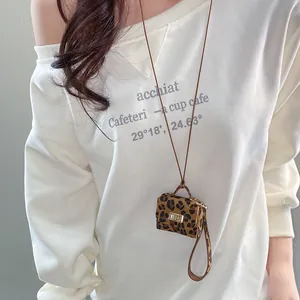 Close-up of leopard print leather micro bag pendant on long leather necklace strap