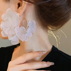 Primer plano detallado de grandes pendientes de aro con flores de malla lavanda en modelo