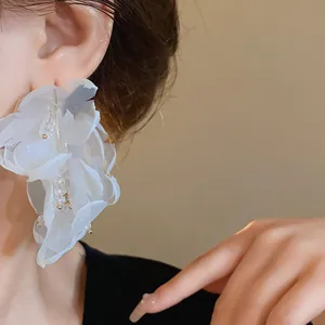 Primer plano detallado de elegantes pendientes de flor de malla blanca con cristales