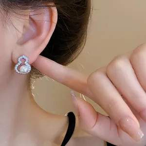 Nahaufnahme eines Hulu-Ohrrings im neuen chinesischen Stil mit Perle und Zirkonia am Ohr