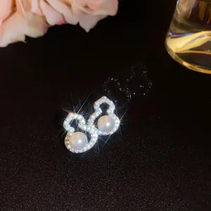 Detailaufnahme eleganter Zirkon- und Perlenohrringe in Kürbisform auf schwarzem Grund.