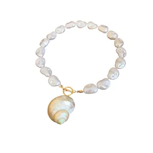 Collana di perle barocche con pendente a conchiglia e chiusura a barra dorata chic.