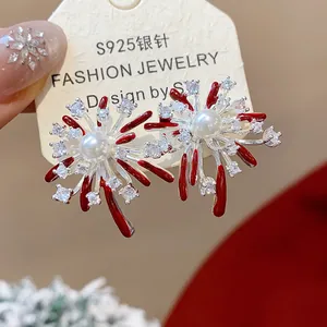Dettaglio squisito di orecchini a forma di fuochi d'artificio con perle e zirconi.
