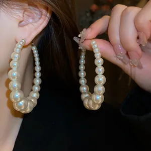 Detailaufnahme großer weißer Perlenohrringe mit einem eleganten glänzenden Finish
