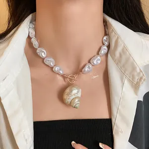 Primo piano della collana di perle barocche con grande ciondolo a conchiglia su modella