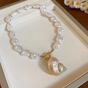 Dettaglio collana di perle barocche con ciondolo a conchiglia naturale e chiusura oro