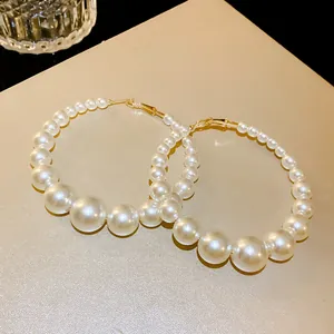Detailansicht von übergroßen, abgestuften Perlenohrringen mit elegantem Goldfinish