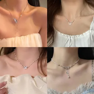 Close-up of elegant butterfly and pearl necklaces worn as a stylish clavicle chain