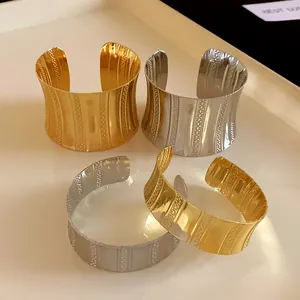 Detail shot of elegant textured metal cuff bracelets in gold and silver finishes.