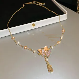Close-up detailed view of butterfly necklace with pastel enamel, pearls and zircon