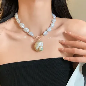 Dettaglio della collana di grandi perle barocche con ciondolo in conchiglia naturale