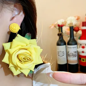 Primer plano de aretes de flores de rafia amarillos en la oreja para un estilo dulce.