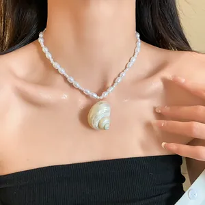 Primo piano di un'elegante collana di perle barocche con ciondolo a conchiglia naturale