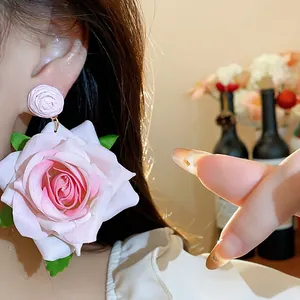 Primer plano detallado de un pendiente de rosa de tela rosa con textura realista