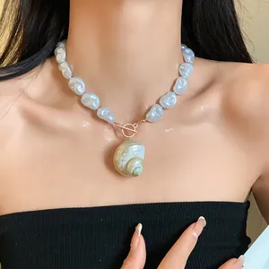 Vista dettagliata di un'elegante collana di perle barocche con ciondolo a conchiglia.