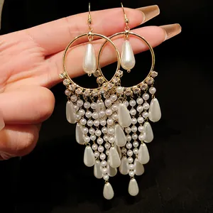 Close-up of elegant vintage gold tassel earrings with pearls and zircon accents